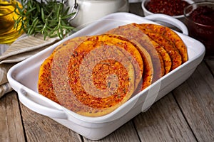 Traditional Turkish Biberli Ekmek Ã¢â¬ÅFlat bread with red pepper pasteÃ¢â¬Â being prepared before cooking in Antakya Hatay, Turkey photo